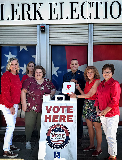 Wear Red for Women presenting an AED in front of the Pettis County Clerk's office